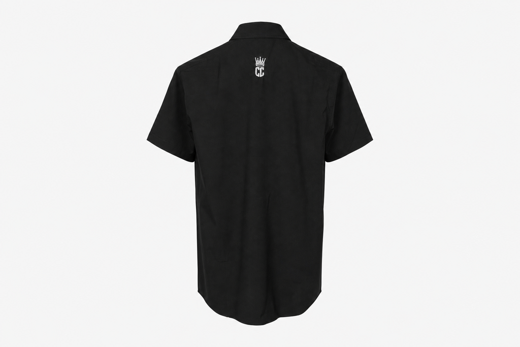 A black short-sleeve button-up shirt shown from the back, featuring a small white crown and 'CC' monogram logo centered on the upper back, set against a plain light gray background.