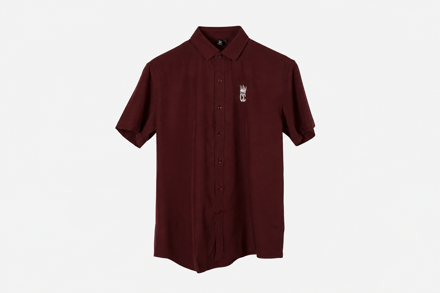 A maroon short-sleeve button-up shirt with a small white crown and 'M' logo on the left chest, displayed on a clean white background.